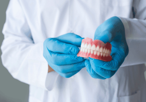 dentist holding dentures for tooth replacement high quality dentures for dental service oral health care