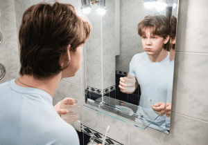 rinsing mouth after brushing teeth to improve dental health and maintain healthy smile between dental cleaning visits